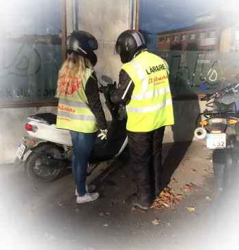 Lärare i Ahlséns-väst går igenom mopeden med en elev utanför trafikskolan